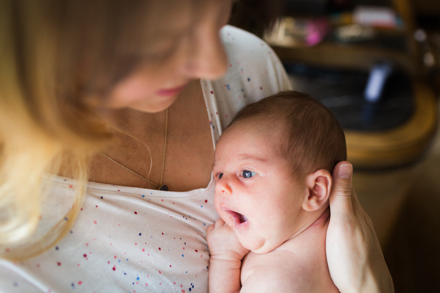 newborn baby yawning in mum's arms in birmingham