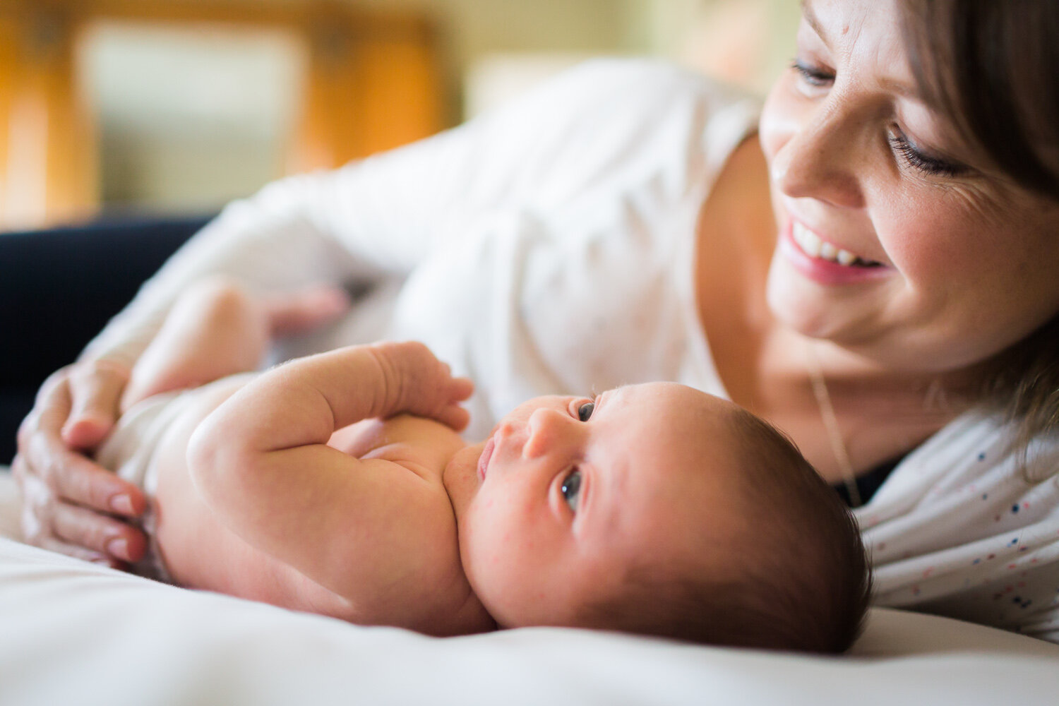 mum smiling at newborn baby at home in edgbaston