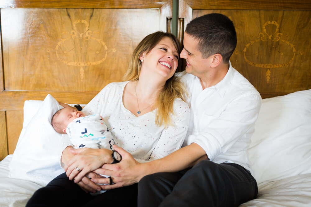 new parents cuddling newborn at home in birmingham