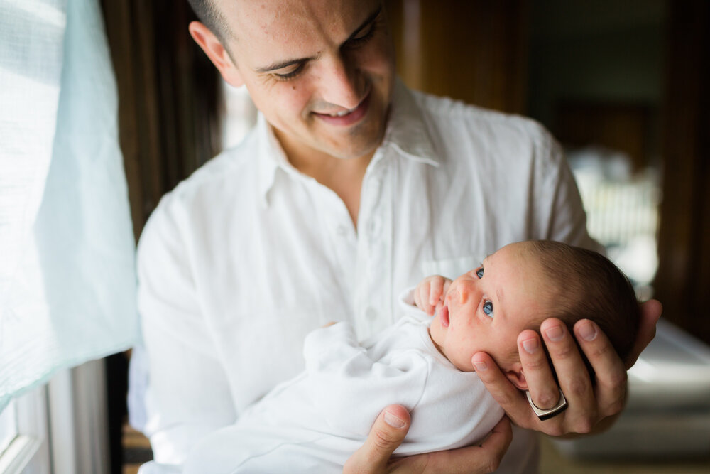 Dad cuddling newborn baby at home in birmingham