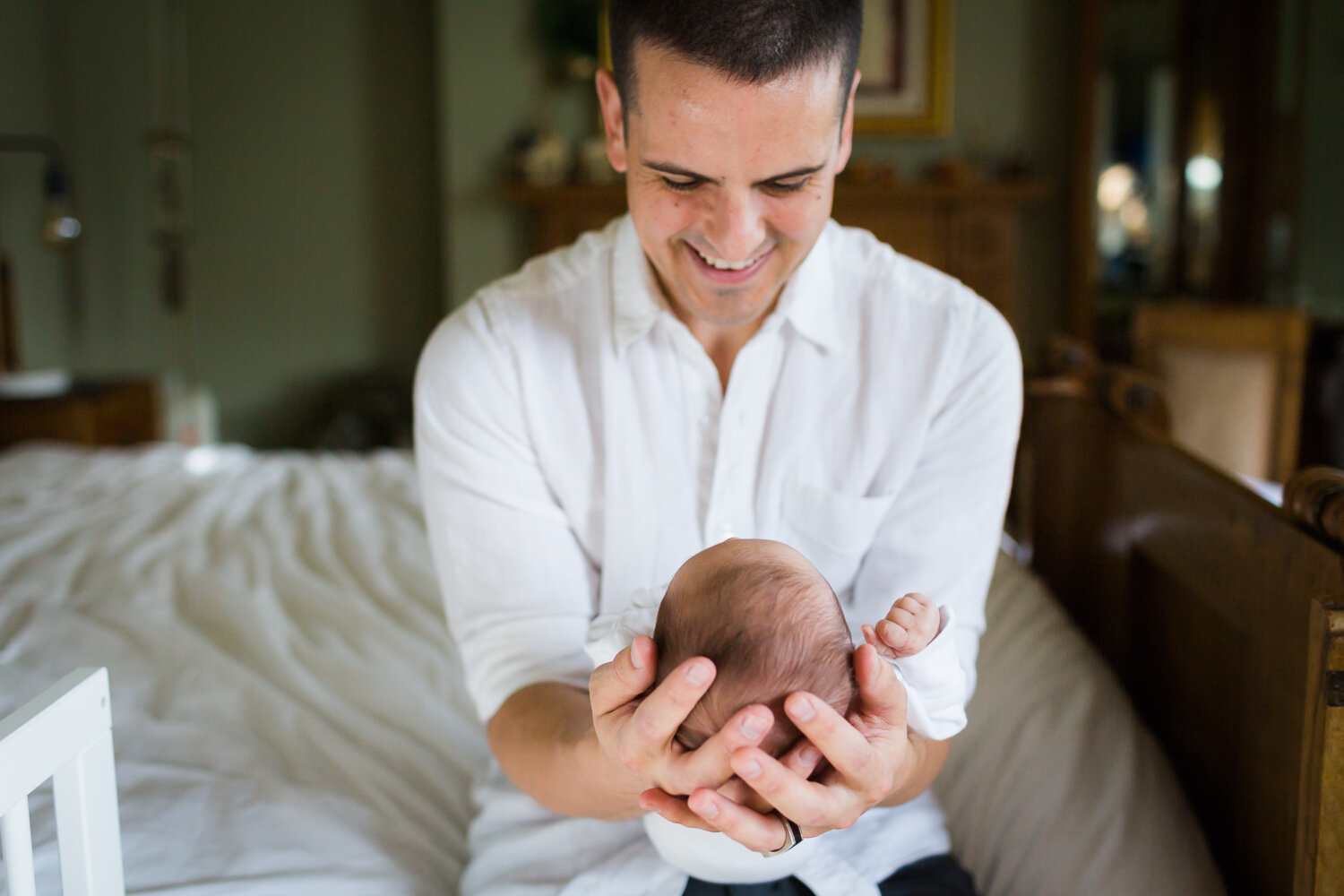 Dad cuddling newborn baby at home in birmingham