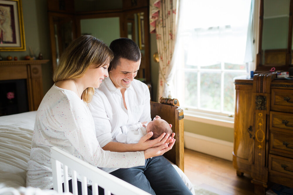 new parents cuddling newborn at home in birmingham