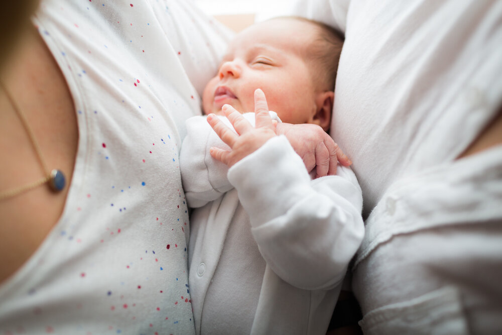 new parents cuddling newborn at home in birmingham