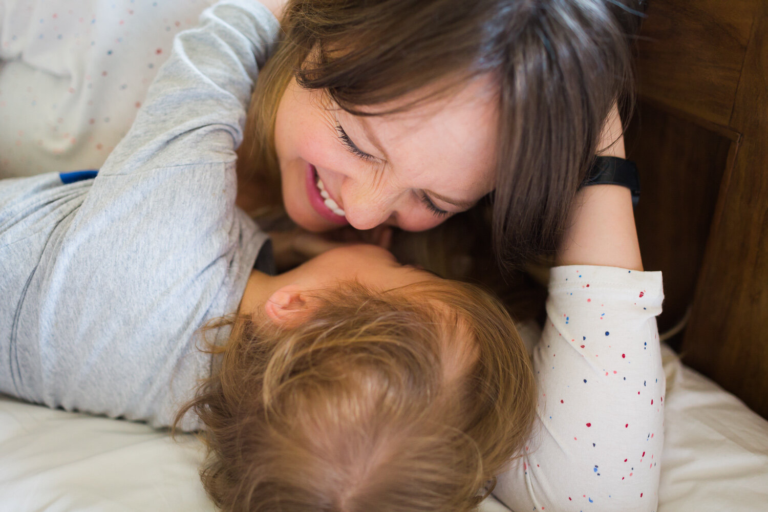 Family enjoying on the bed with newborn baby in birmingham