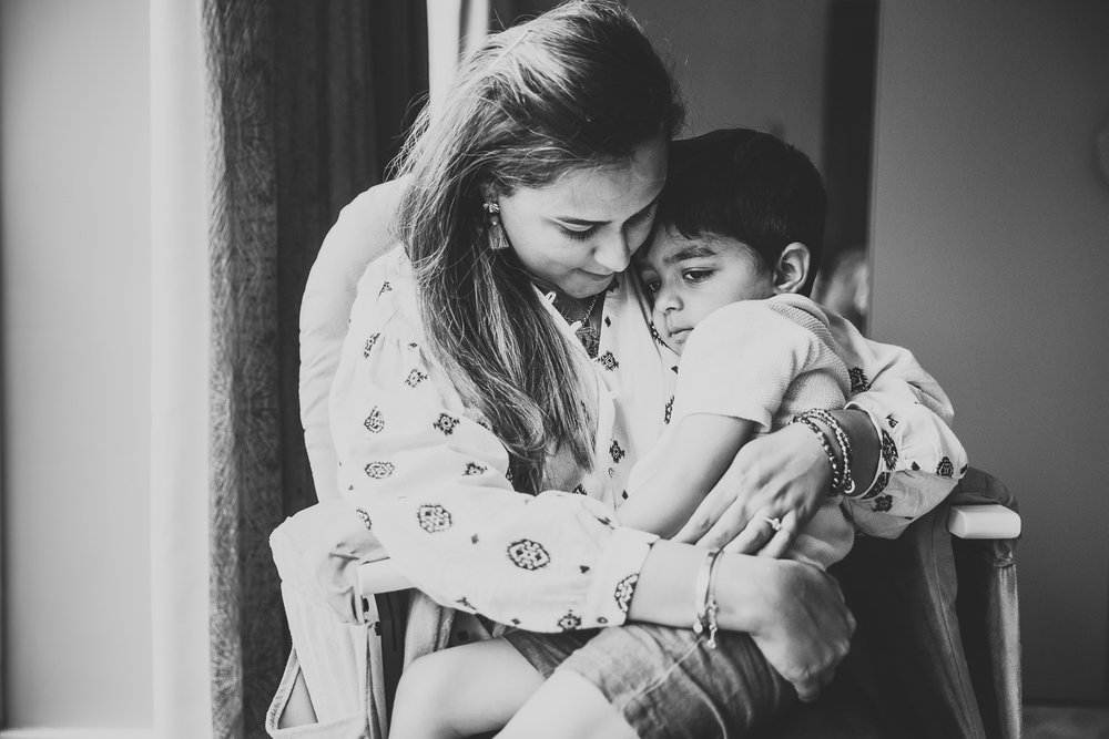 In-Home Family Photo Session In Wimbledon with son snuggling up to Mum