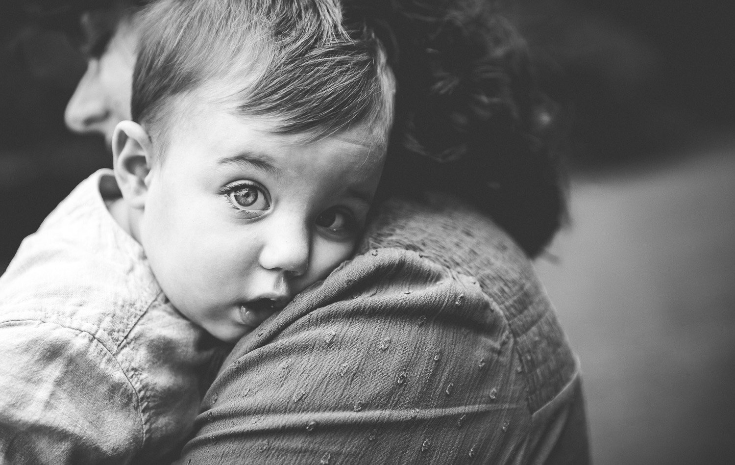 One year old looks directly at the camera in outdoor family photoshoot in wimbledon