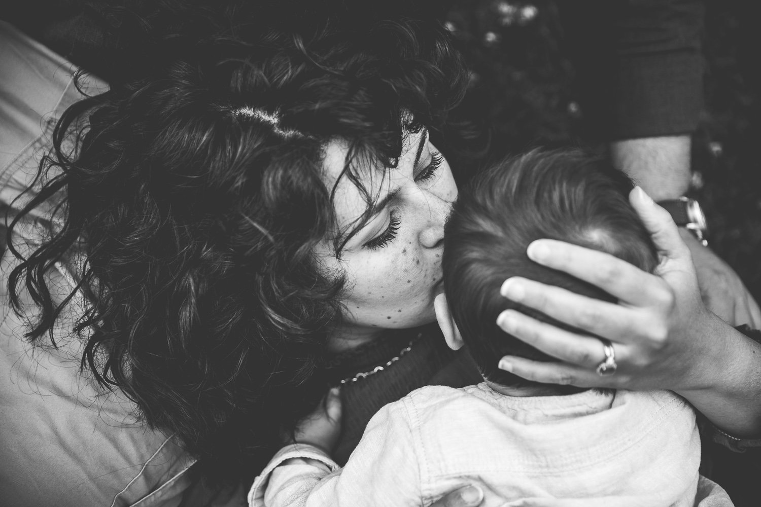 Mum lovingly kisses one year old toddler in outdoor family photoshoot in wimbledon