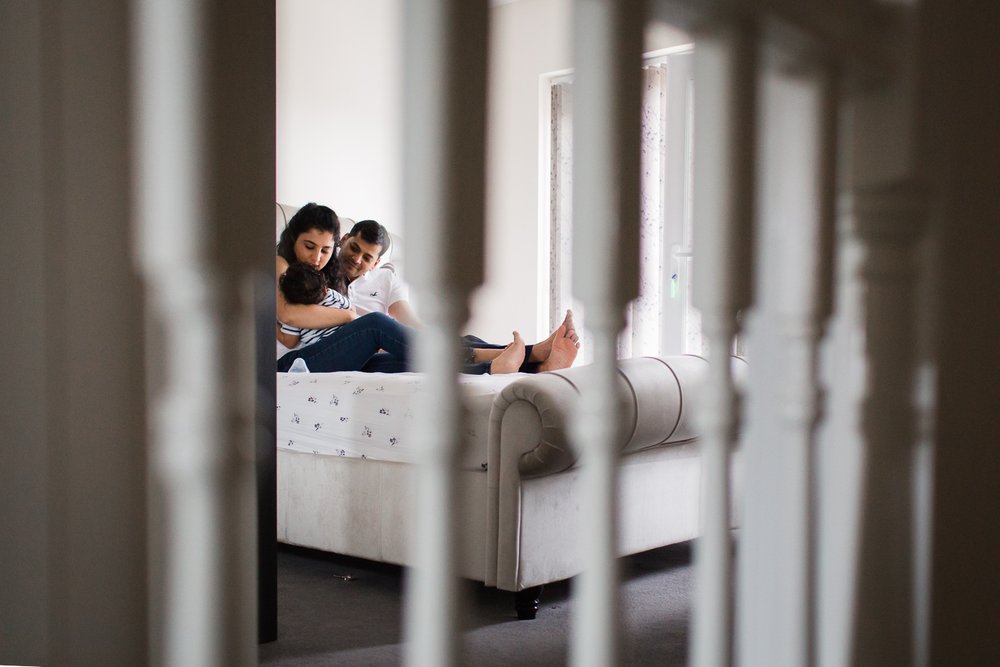 Wimbledon Family Photographer captures parents hugging 6 month old baby at home