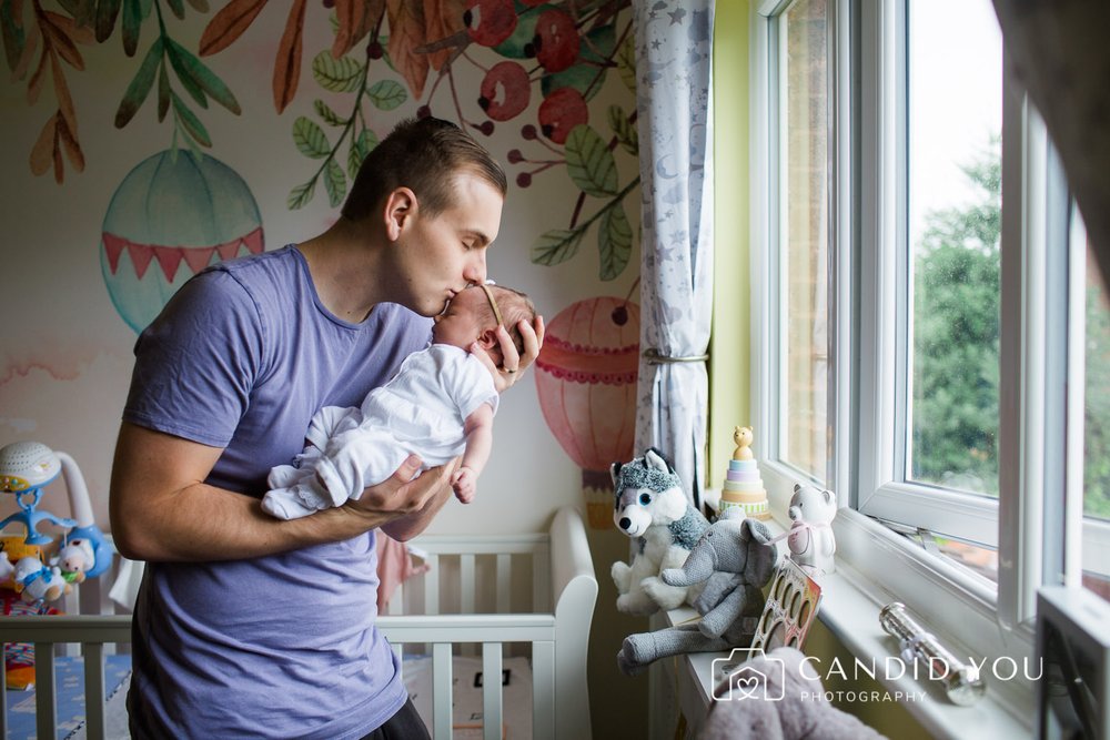 dad intently kisses newborn in kingston