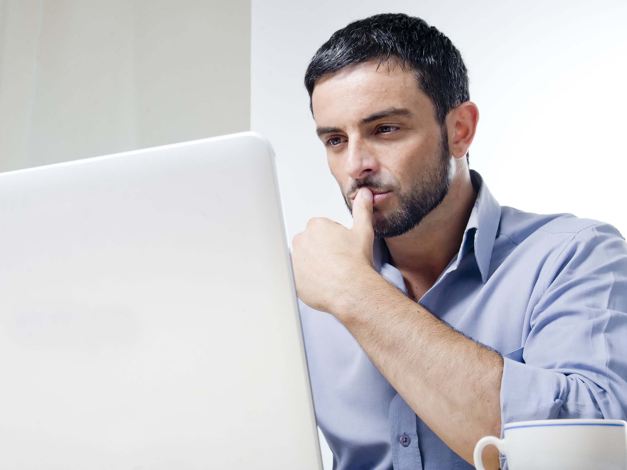 Young Man with Beard working on Laptop by OcusFocus TRADUÇÃO E REVISÃO DE TEXTO