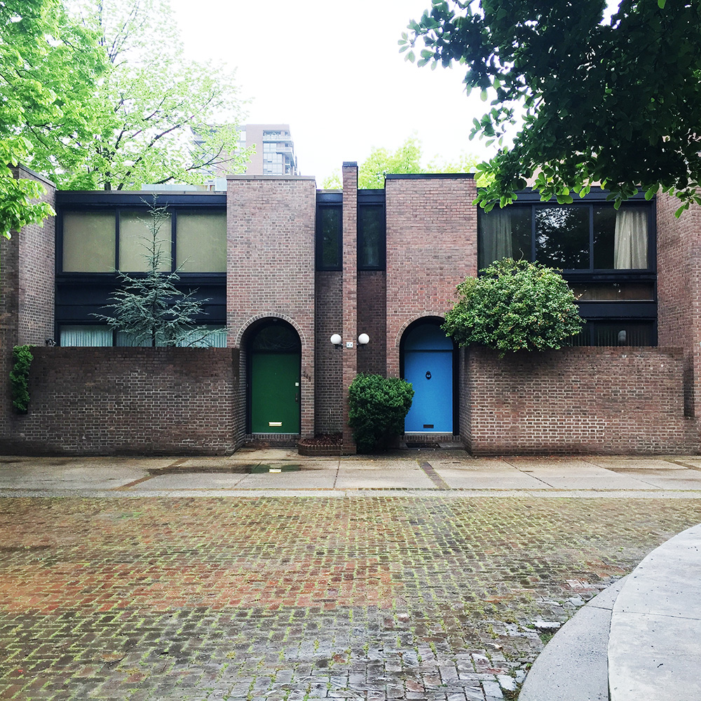 Photo of Bingham Court as it looks today. This is a view showing mirrored units with their unique colored doors and private yards.