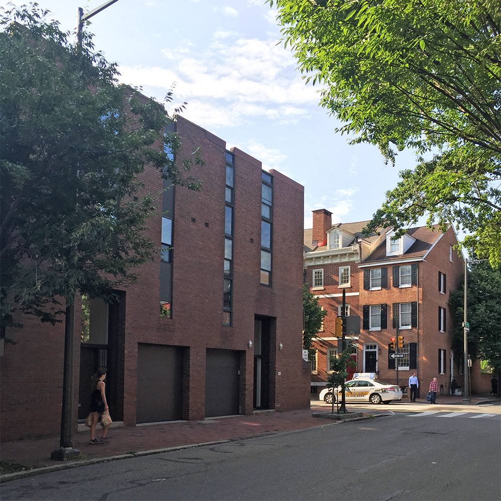 Photo of a Brick Modern building from the late sixties and adjacent colonial houses.