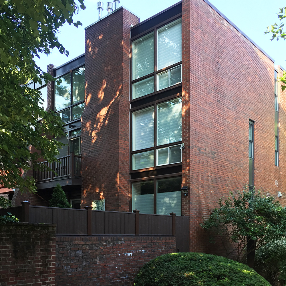 The same house pictured above, this photo shows the large open windows along the rear of the house and small fenestration along the public facades.