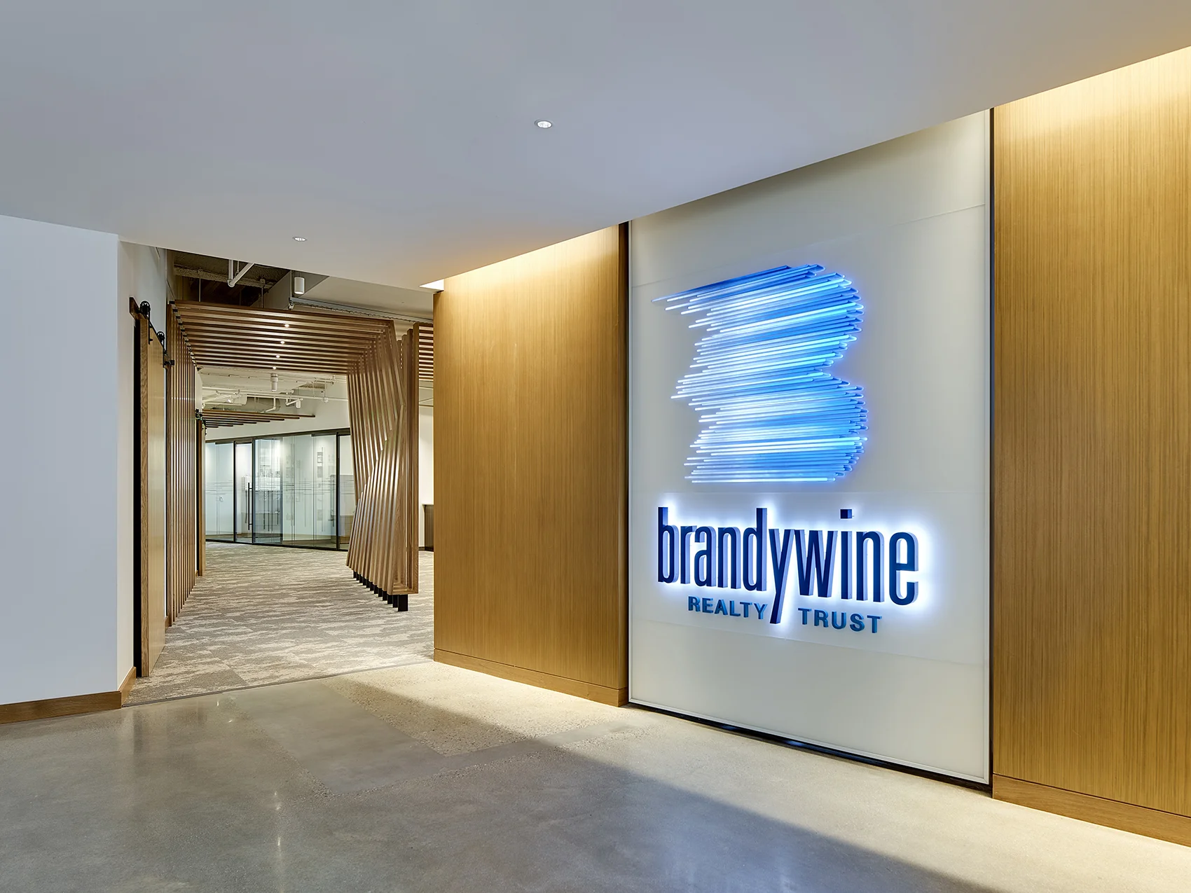Entry Sequence: The design of the lobby and entry procession features a natural wood wall with a moment of infused branding.