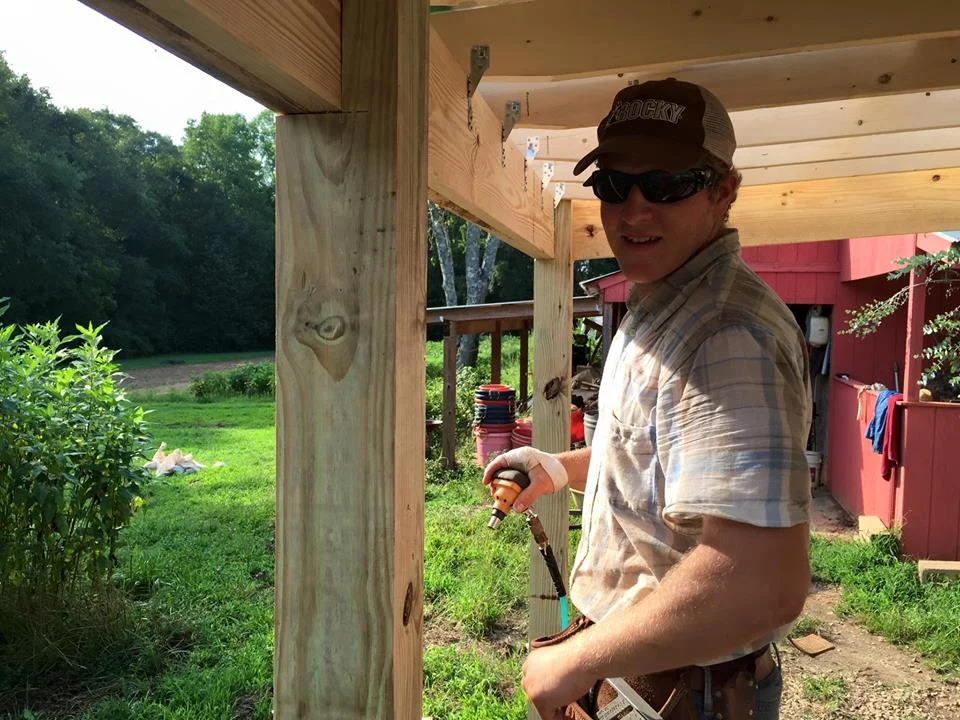 Gillen, Nicolas's oldest son, building the Farm's new outdoor wash station. While he is a skilled carpenter creating his own business, he still finds time to help his Dad on the Farm.
