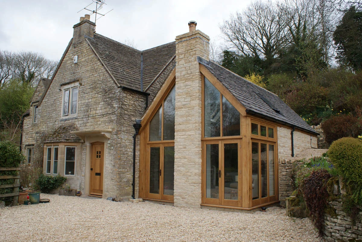 Gransmore Architects — cotswold oak frame timber glass extension pitched roof light statement chimney stone heritage period property architecture project architect sustainab