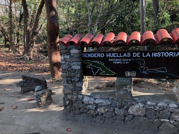 Next to this trail map near Trinidad, stocks once used for enslaved persons have been preserved. Cubans own their history in ways North Americans may find surprising.