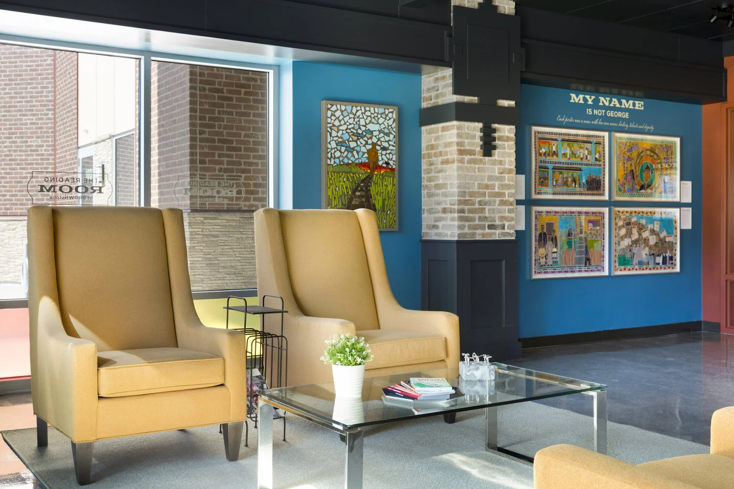 A chrome coffee table provides the perfect contrast to the bronze side table and black iron-inspired details surrounding this commercial space (The Reading Room in St. Paul) / Vela Creative