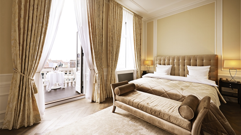 A beautiful room at the Hotel d’Angleterre opens onto a spacious balcony with a view of the city.