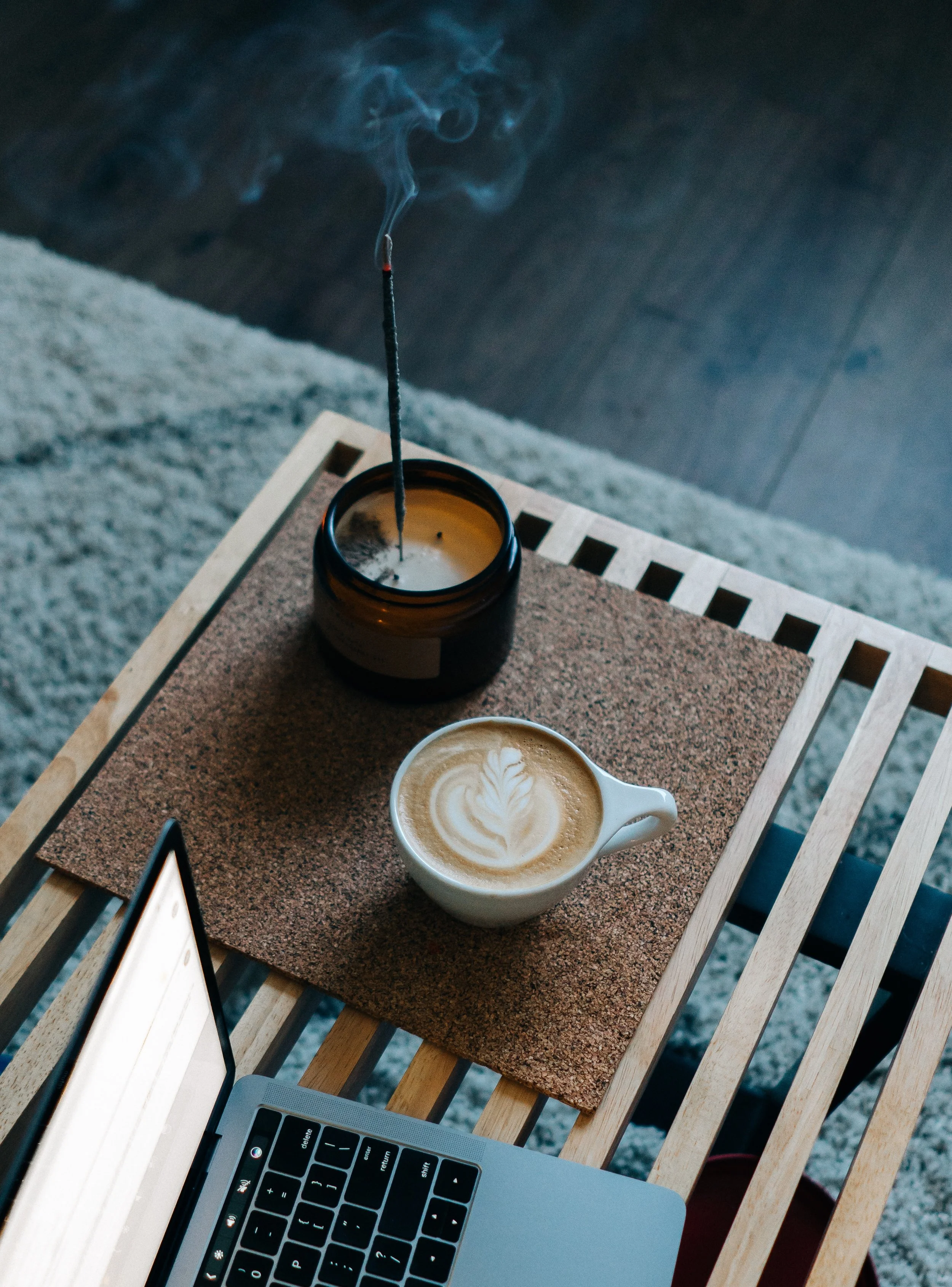 A cup of freshly-brewed coffee and slowly-burning incense pulls scents of nature into this workspace / Image Source: Mike Marquez via Unsplash
