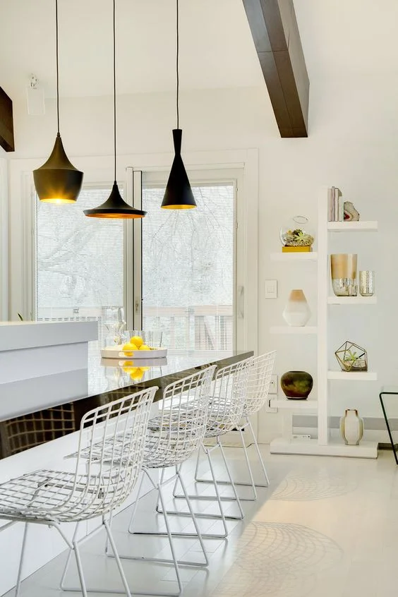These standing floating shelves in our Modern Sophisticate design work to showcase a curated collection of sculptural items, connecting the geometric elements of the space and giving a metallic flair to the whitewashed space. / Design by Vela Creative