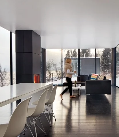 An open floor plan allows for a seamless transition between kitchen, dining room, and living room – all within view of the roaring modern fireplace. / Source