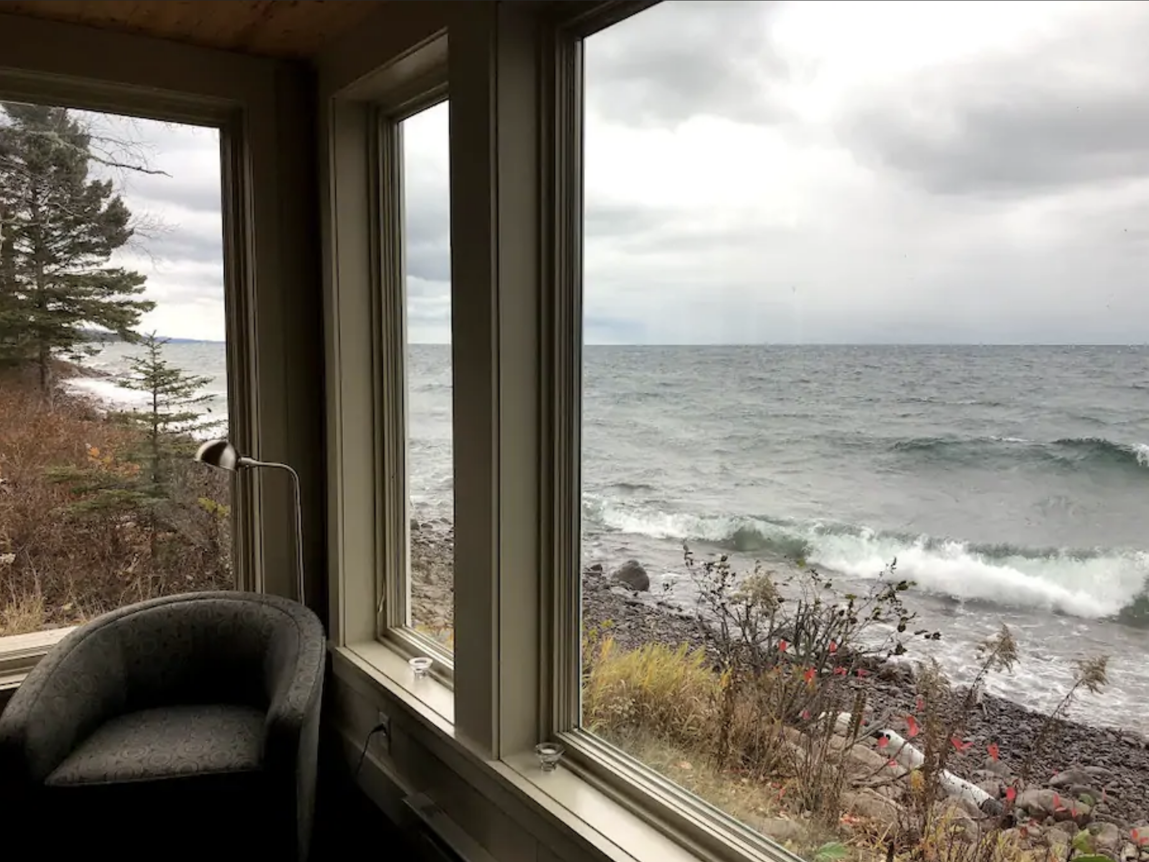 A picture window provides up-close views of the waves of Lake Superior and provides the perfect cozy nook for relaxing. / Source