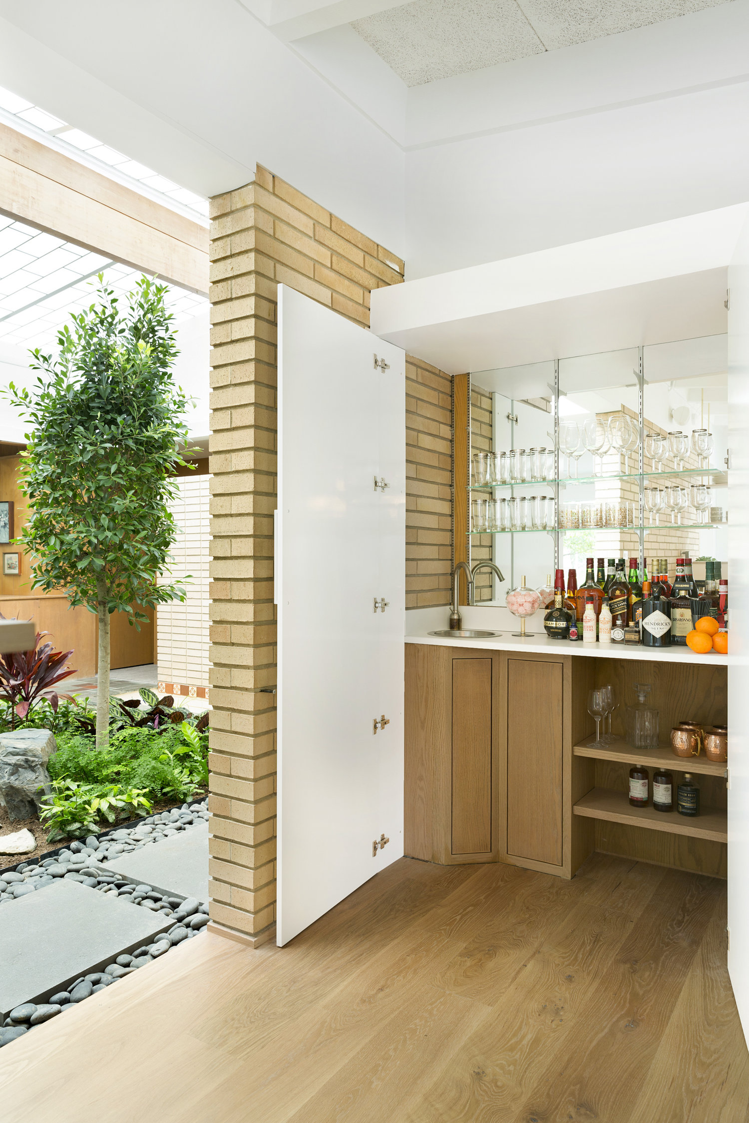 The open-air indoor atrium in our Midcentury Revitalization project provides a relaxing escape in any season, helping the home come alive and its owners stay connected to nature, whatever the weather may be. / Source: Vela Creative