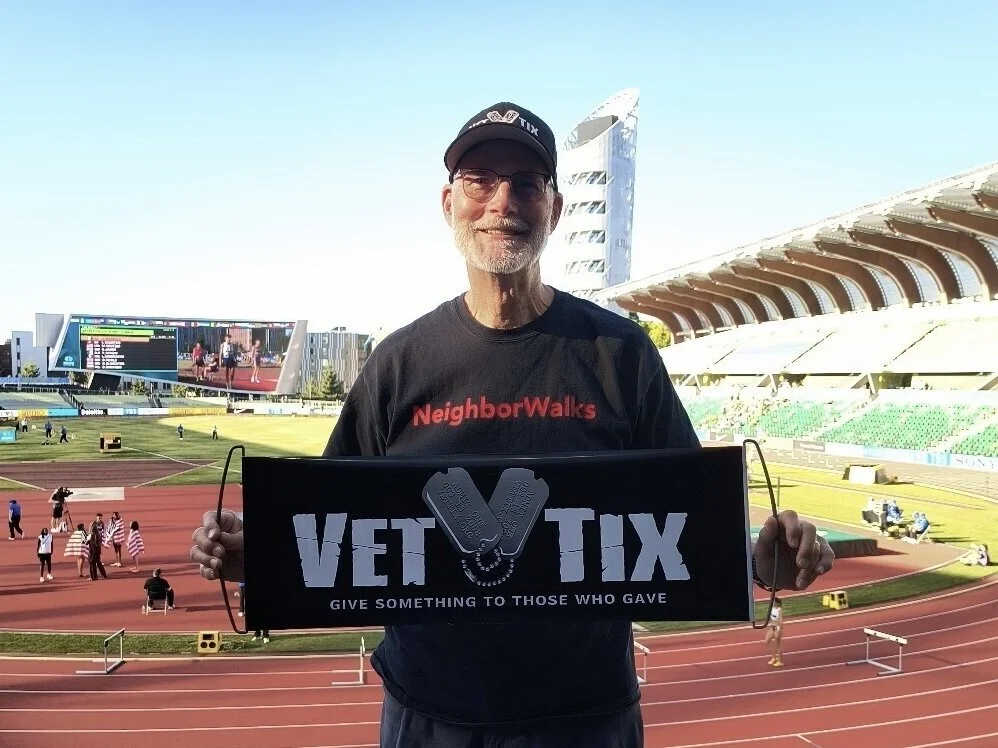 A man holding a Vet Tix banner at the World Athletics U20 Championships Oregon 26 at Hayward Field at the University of Oregon.
