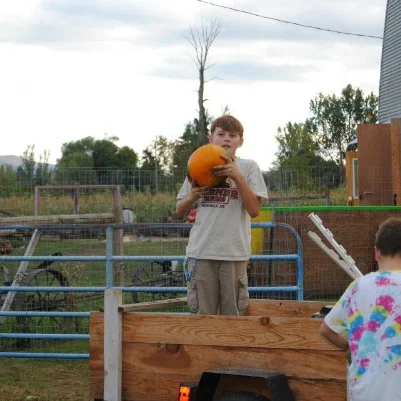 OUR OLDEST SON WAS PART OF THE FIRST CLASS FROM HAWTHORNE SCHOOL TO HARVEST PUMPKINS AT THE FARM. SINCE THESE HUMBLE BEGINNINGS, OUR HARVEST HAS GOTTEN BIGGER, OUR TRAILER HAS GOTTEN BIGGER AND OUR SON HAS GOTTEN BIGGER TOO!
