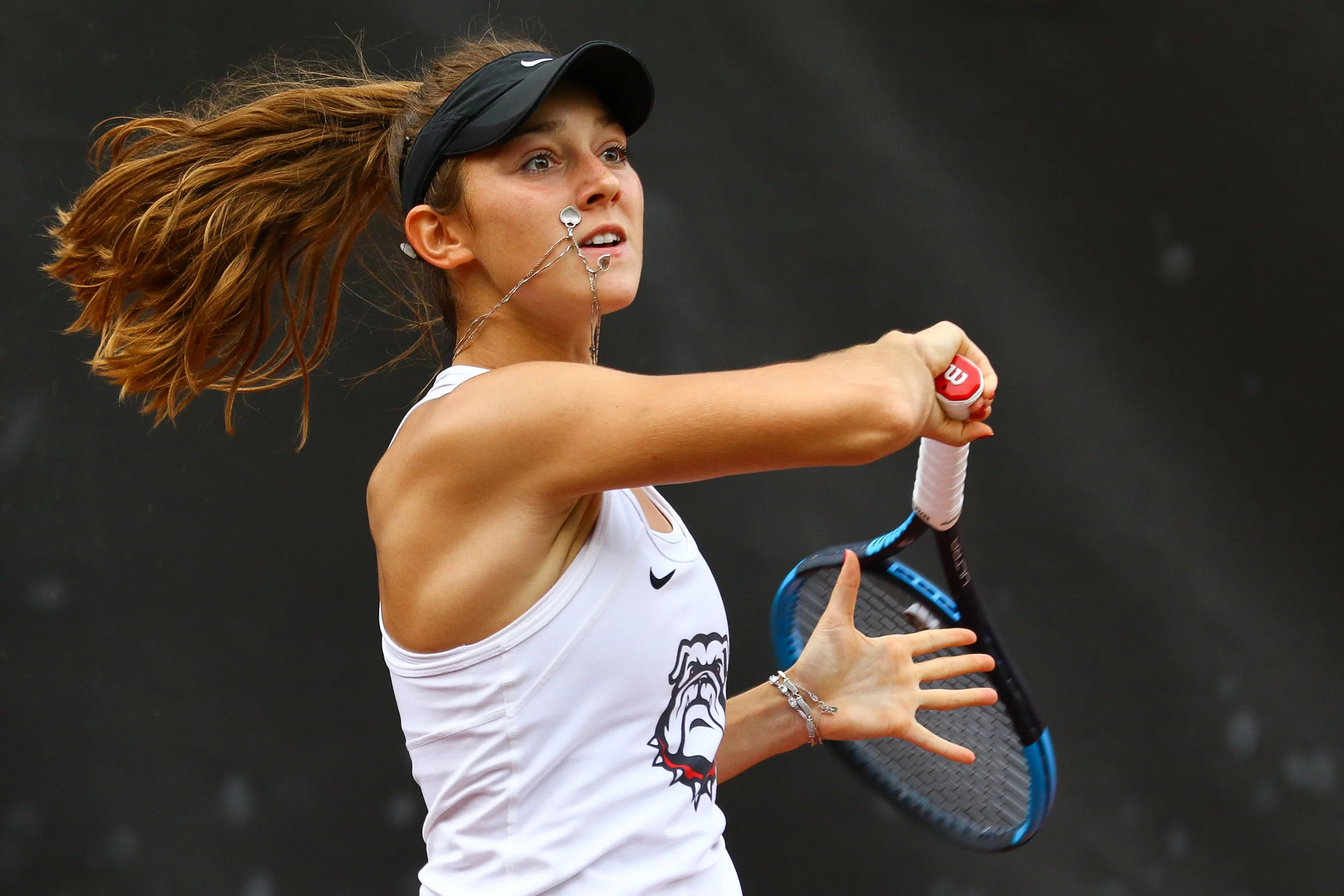 Georgia's Katarina Jokic's necklace hits her cheek as she returns the ball during a singles match against Kentucky in Athens, Ga., on Friday, Apr. 12, 2019. Jokic’s grandmother gifted her the chain, while her mother supplied the charmed heart. She w