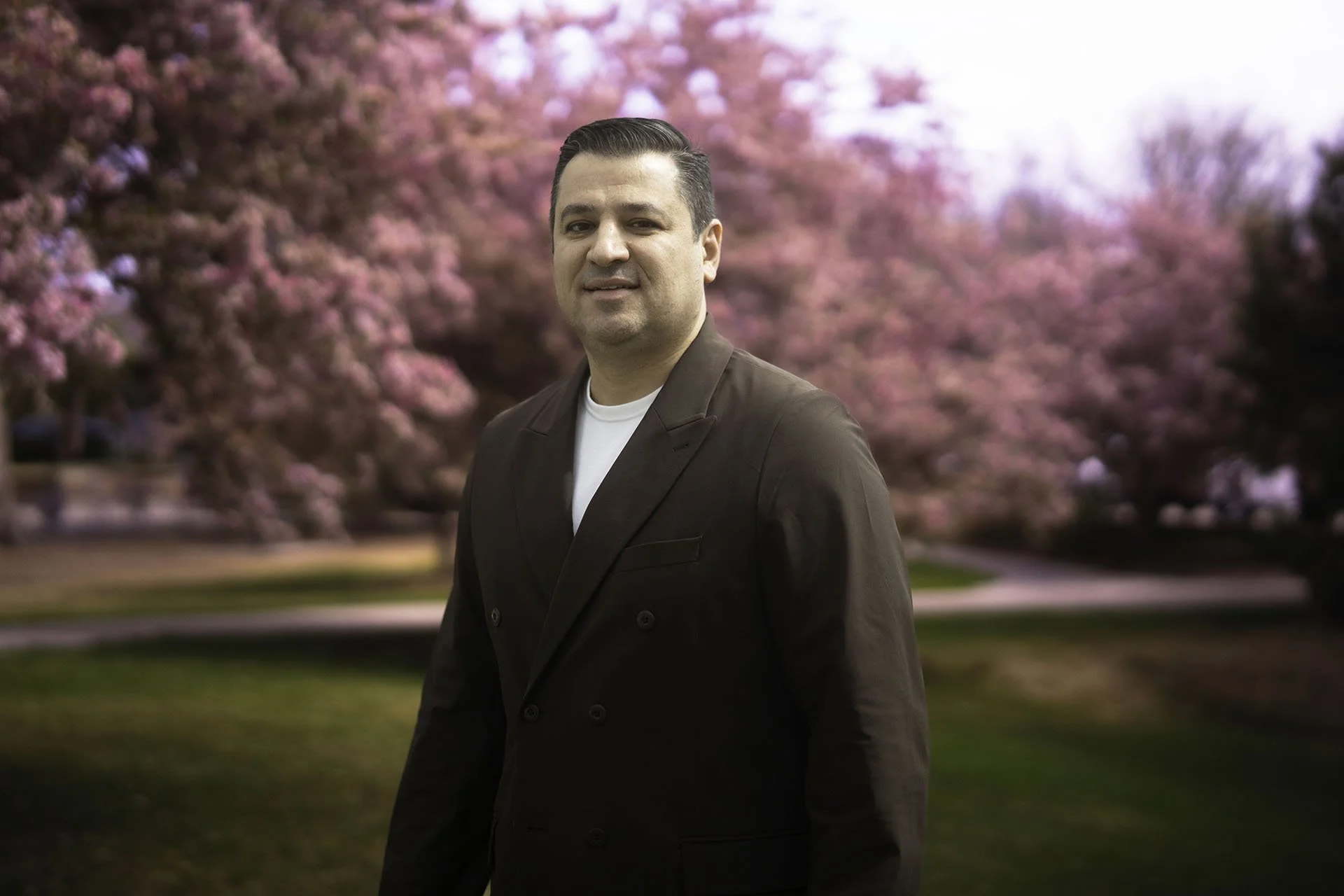 Ioannis Minas posing outside amongst a backdrop of trees and greenery.