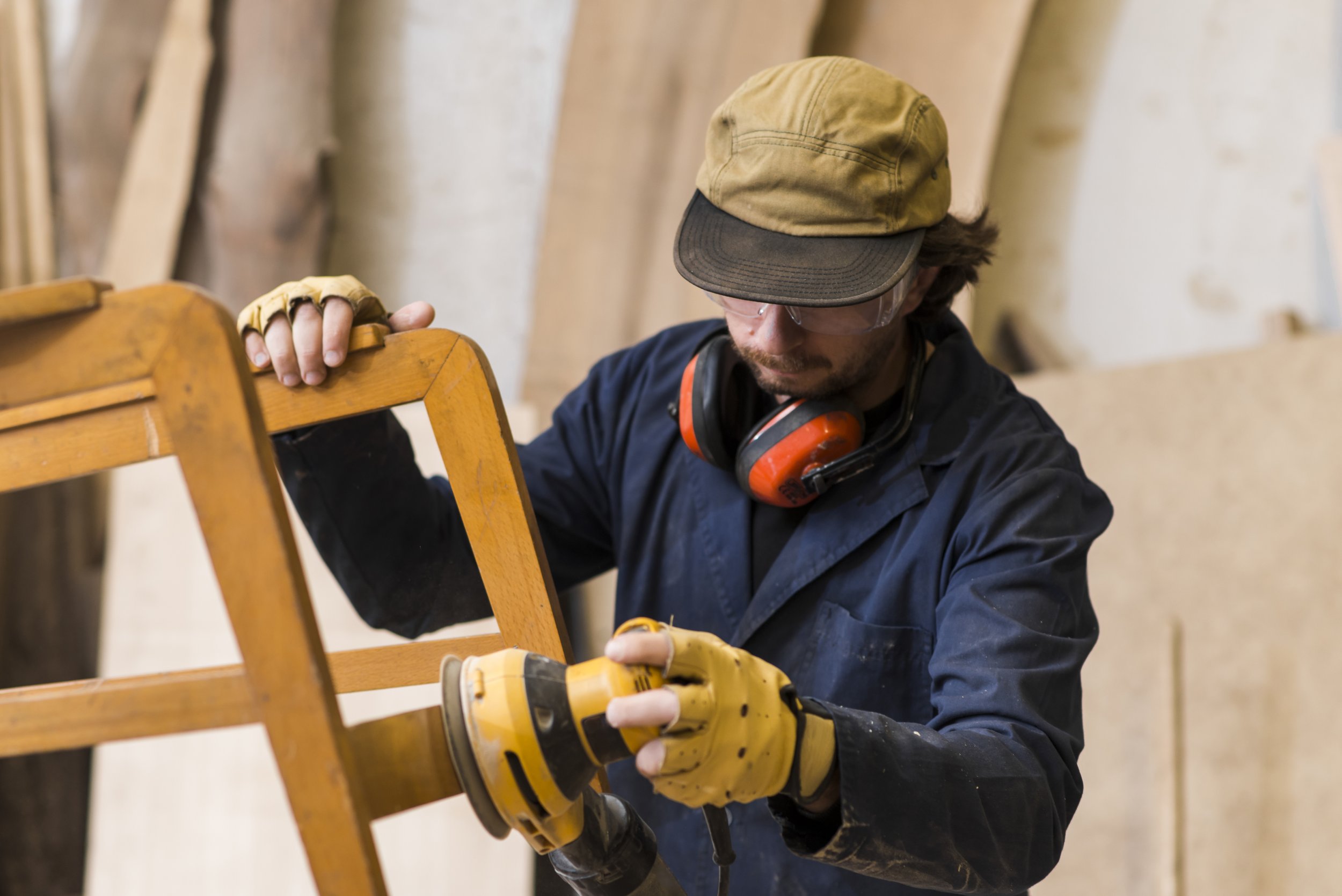 professional-carpenter-polishing-wooden-chair-with-electric-sander.jpg