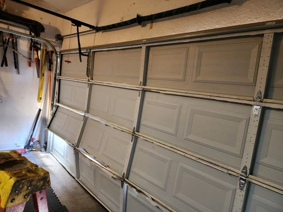 damaged-garage-door-repair-misaligned-panels-good-golly-garage-doors-austin-round-rock-georgetown-8cd6d3c3-c246-420c-a72a-a15e6083e7ff_compressed.webp