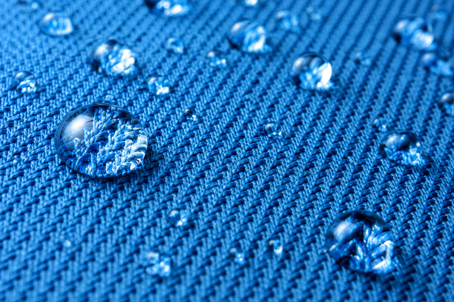 Close-up of water droplets on blue textured fabric