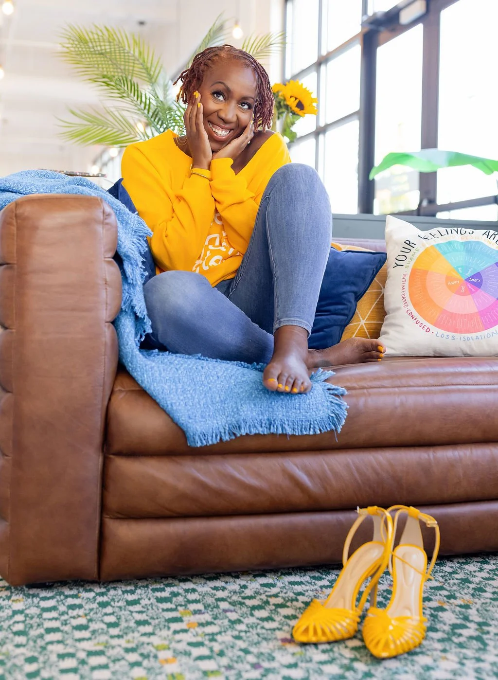 Bianca Hughes, perfectionism therapist,  sitting on couch with feelings wheel, offering soul-aligning therapy in person in Atlanta