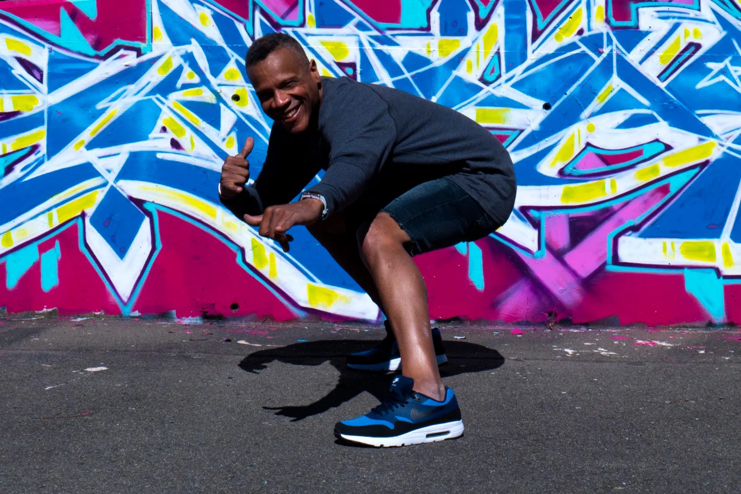 Lavie Raven crouching in front of his graffiti.jpg