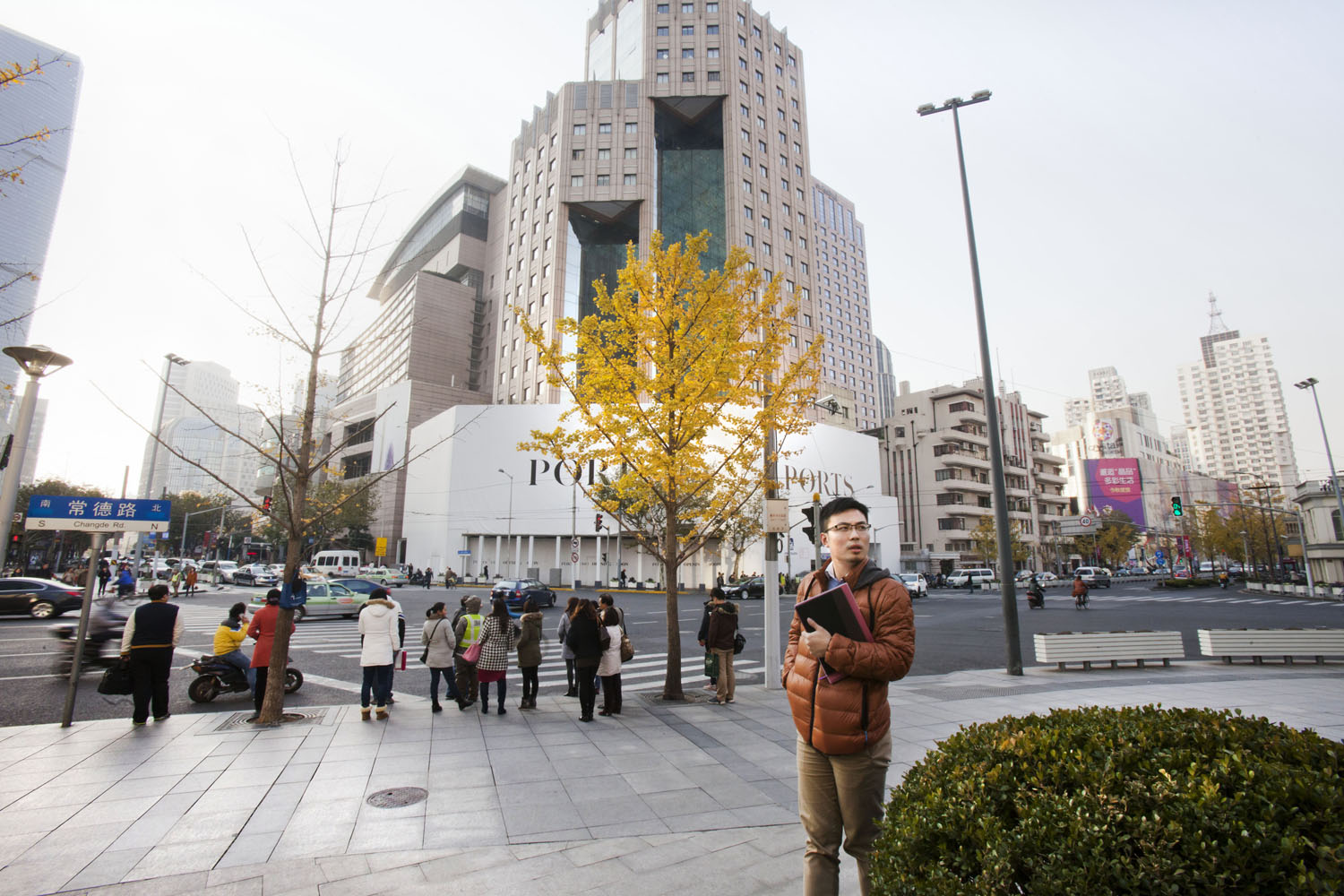A yellow tree and a man waiting on Changde Road in Jing'An. Shanghai, China. 2014.