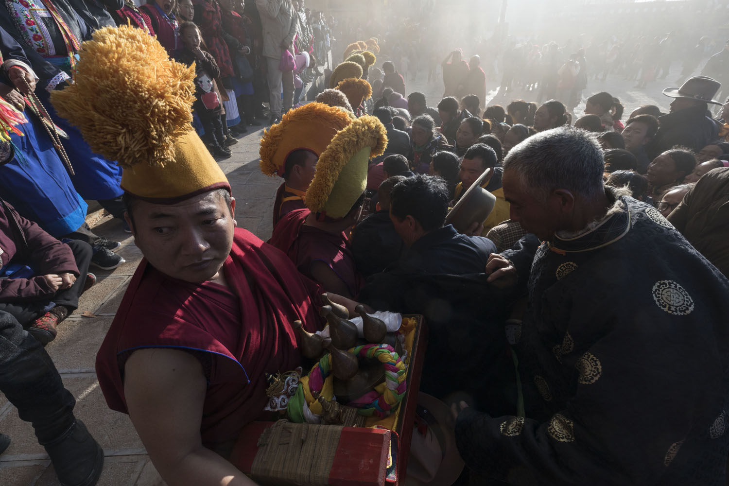 Devotees make offerings of prayer in return for blessings by the Tibetan Buddhist monks at SongZangLin Monastery in JingXiang Village. Yunnan, China. March 2, 2018.
