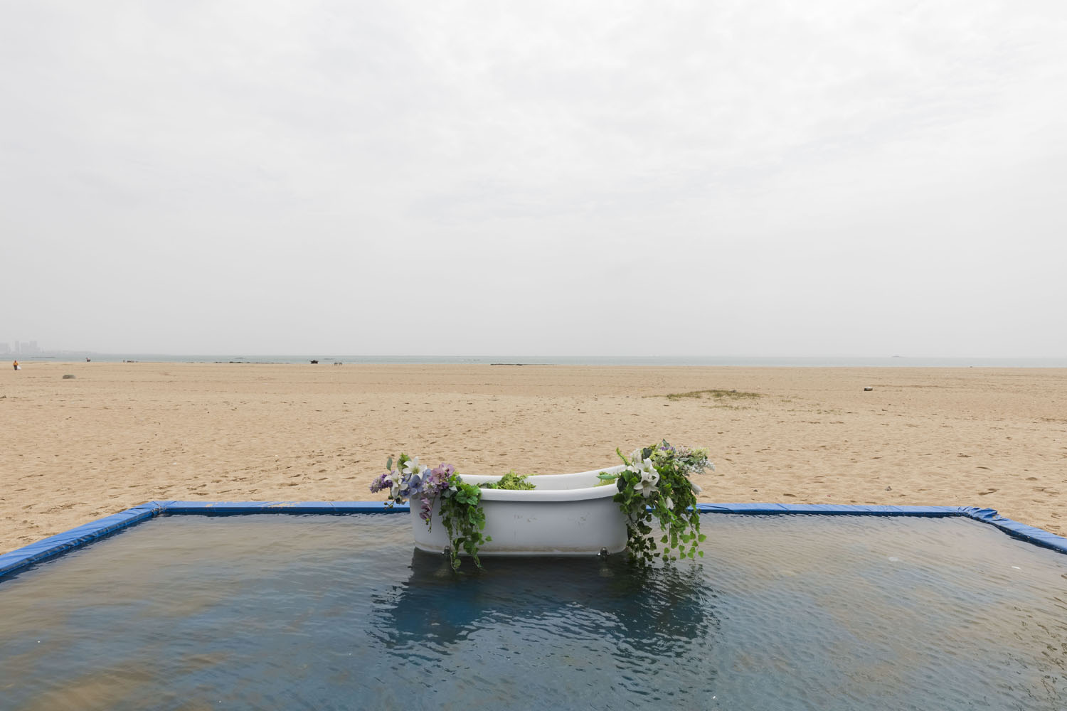 Bathtub and imitiation flowers sit inside a small pool, used for wedding photography at Guanyinshan Fantasy Beach. Xiamen, China. 2018.