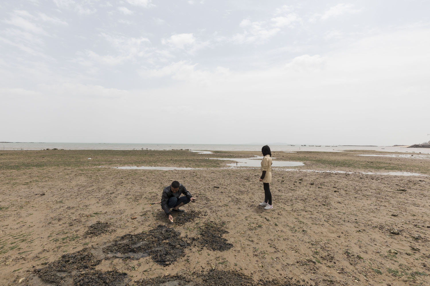 Locals dig for shellfish at the north end of Guanyinshan Fantasy Beach. Xiamen, China. 2018.