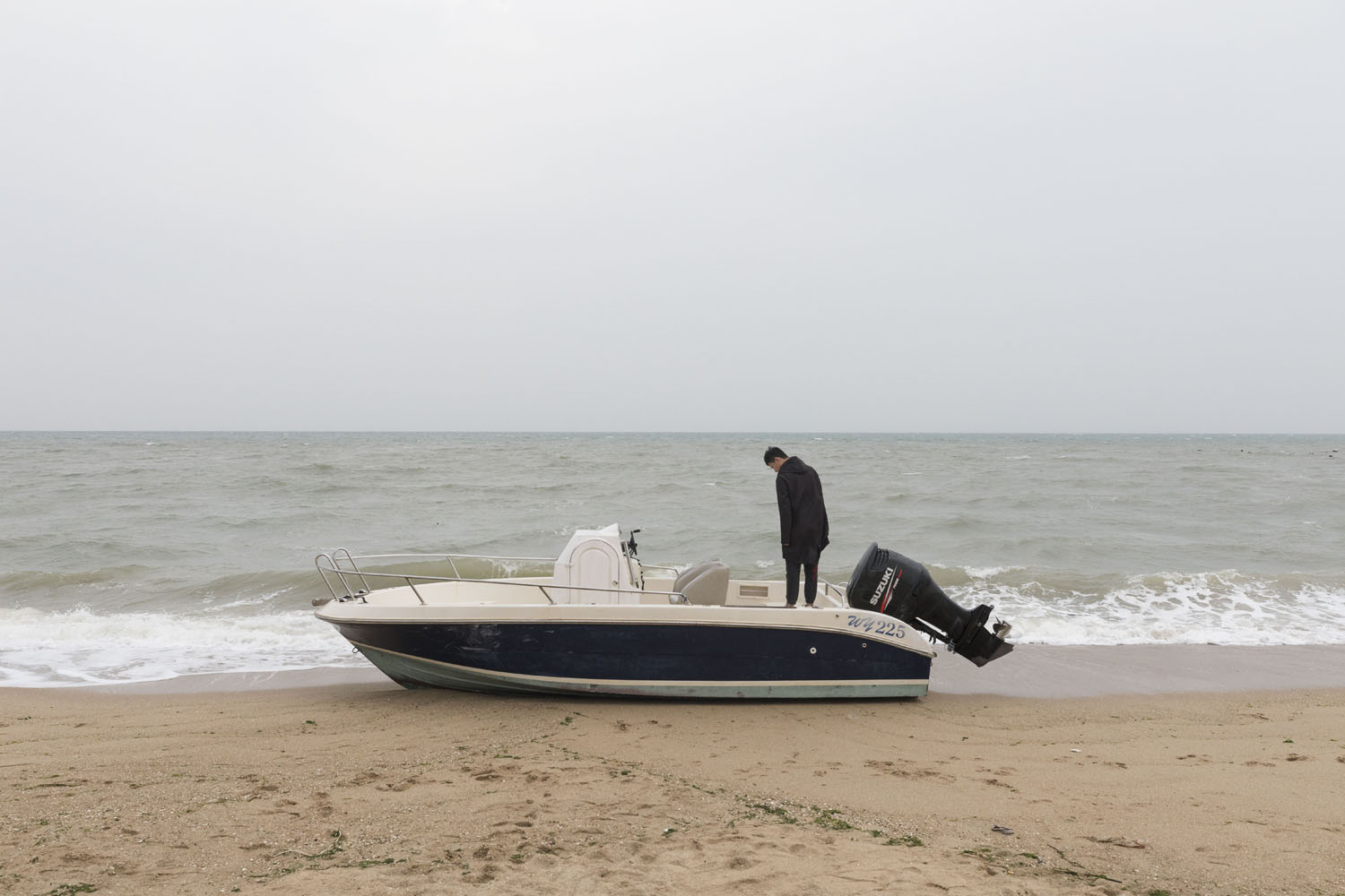 A beached boat used for beach goers and tourists at Guanyinshan Fantasy Beach. Xiamen, China. 2018.