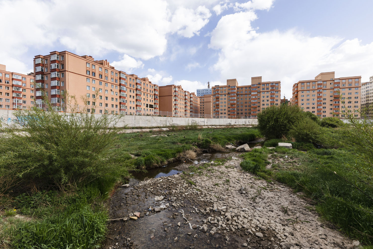 Apartment blocks serve as a backdrop to the Selbe River. Ulaanbaatar, Mongolia. 2018.