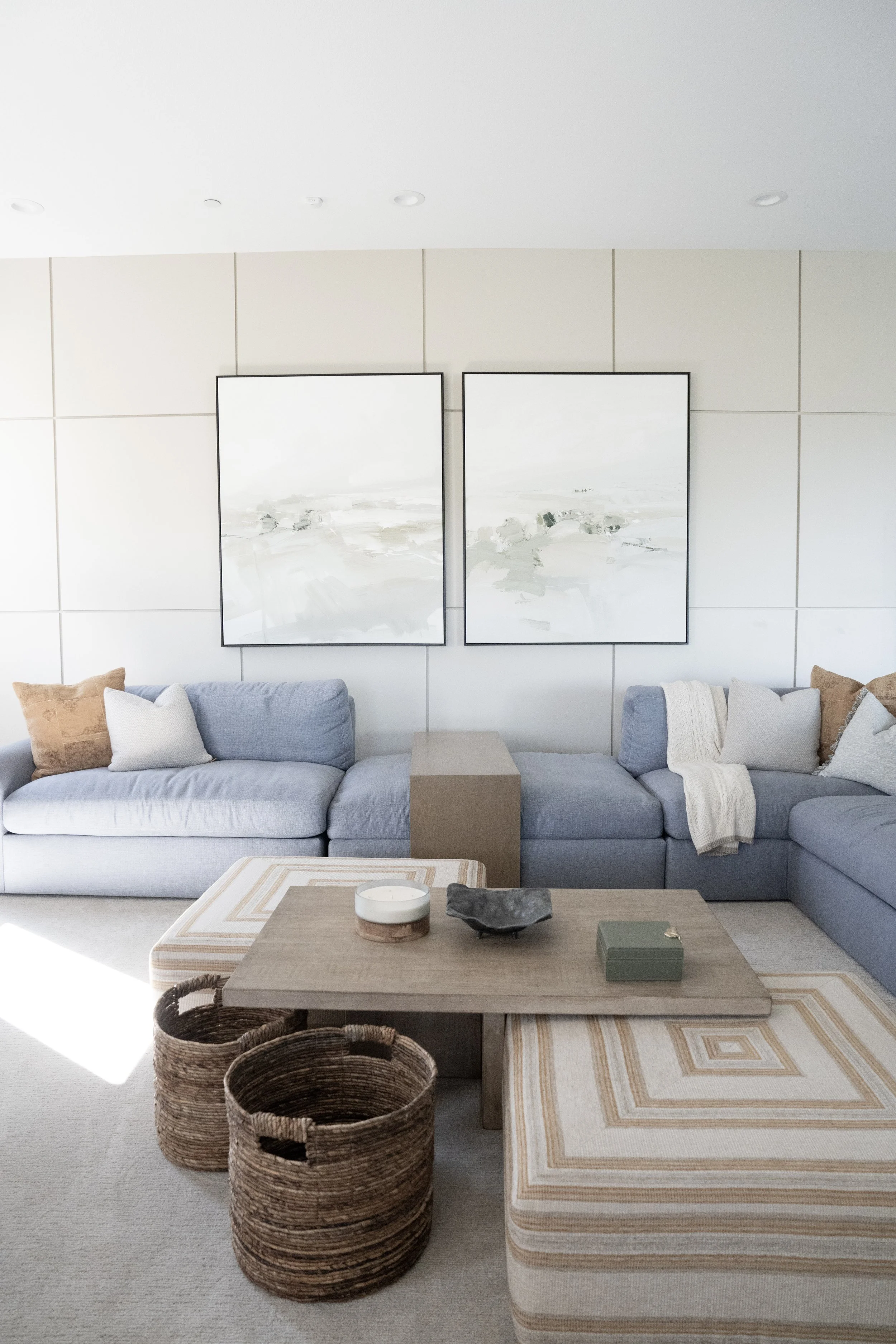 An organic modern living room designed by Savvy Interiors, featuring a blue sectional sofa, custom wall paneling, and curated decor as part of a San Diego whole home remodel.