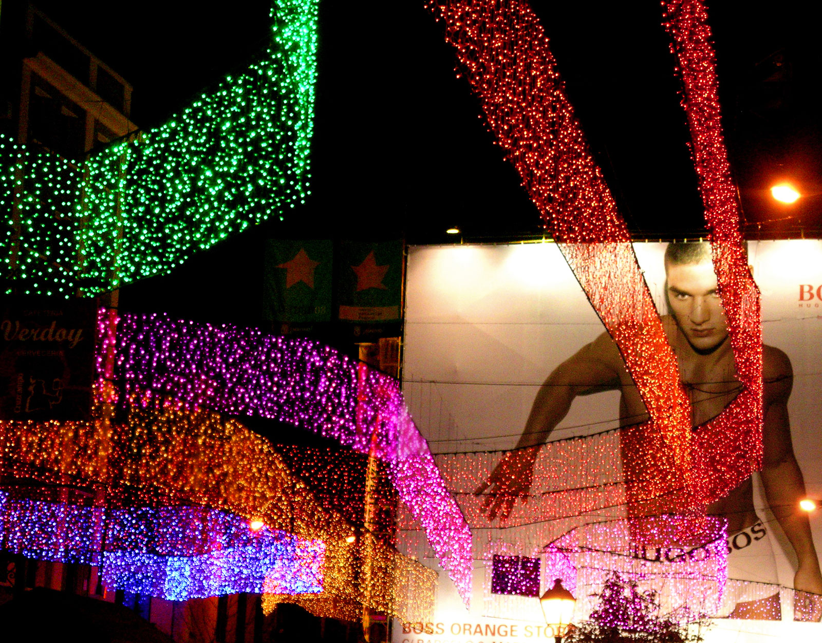 Chueca neighborhood, in Christmas, is illuminated with color streamers, which come from different places, snaking over the streets at the whim of the wind, and building spaces and environments from the joy of the light. Each one acts as a claim that attracts and leads the walker to the heart of the neighborhood, the square in which all of them meet and entwine like a cheerful and spectacular multicolored knot. Again, surprise act as main purpose of the installation, in this case advanced by single streamers in each street around square.