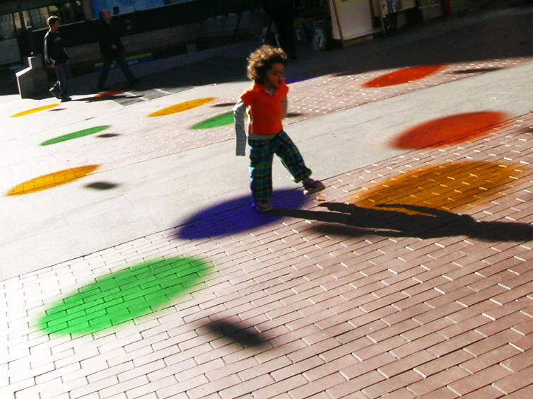  Sunny mornings, children play with dots that colour the granitic soil, young people enjoy a snack of colors, and old people chat around an orange circle which acts as a "moderator."&nbsp;Looking up is like wearing coloured glasses that glad and deco
