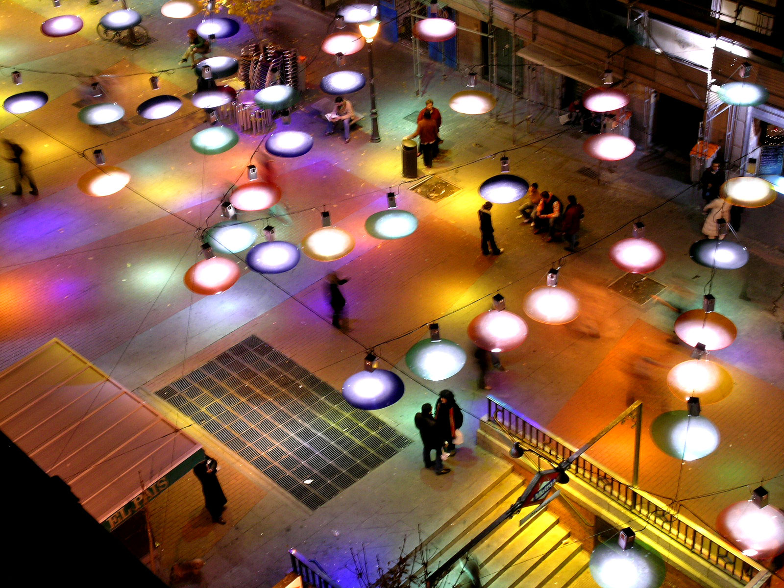 When the night falls, these colour plates are transformed into a bright confetti falling from the sky and express joy, and why not, the festive character of Christmas; it deals with producing an event, the singularity of a fact which doesn´t happen every day ... Exiting the subway and find a ceiling that covers us by surprise, which reflects all the light it receives, and generates a large coloured carpet, on which people meets.