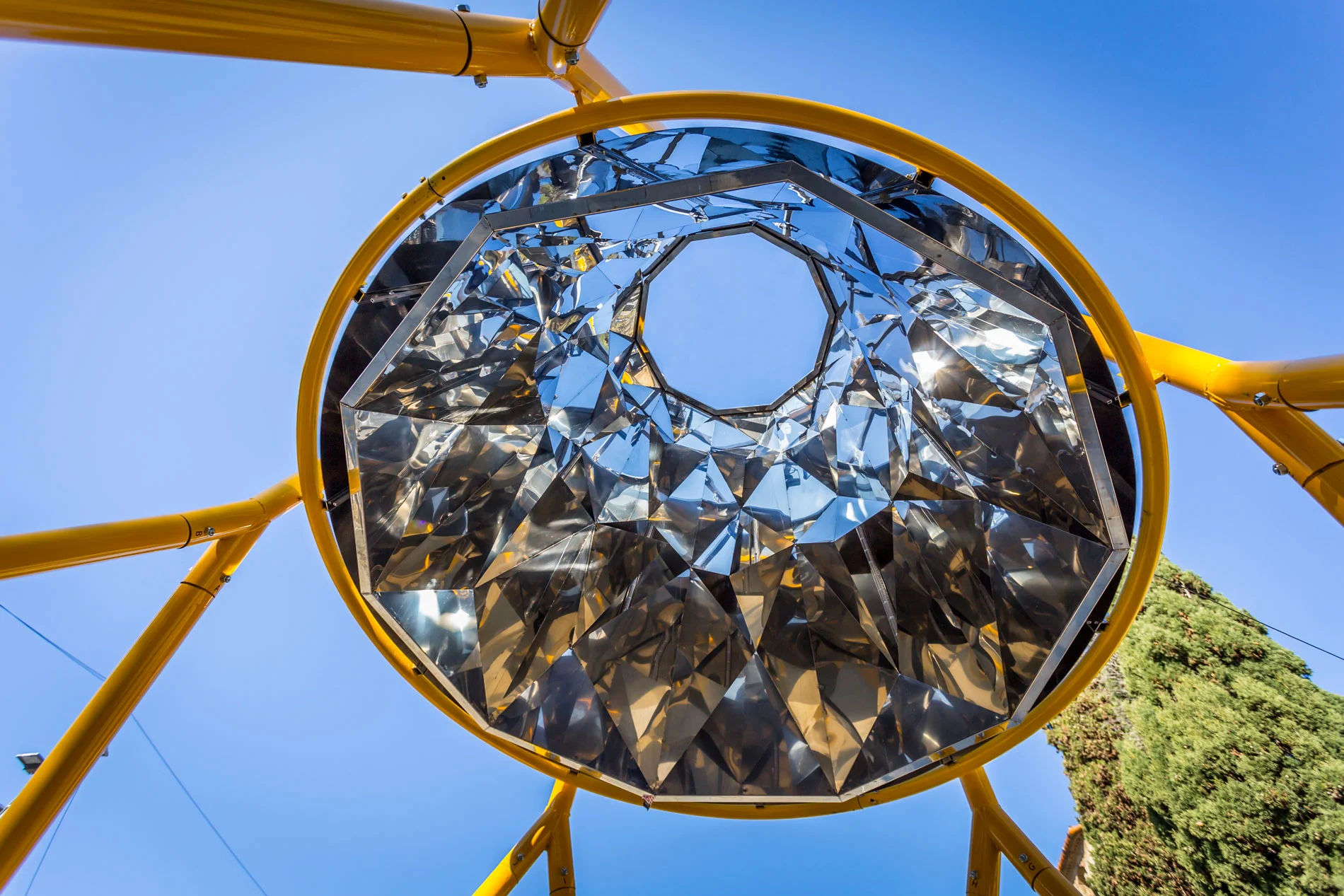 Bell #2. Kaleidoscope Yellow bell gets thinner to show a marvelous kaleidoscope, that reflects sky, city lights and the citizen. As a giant piece of ice glass, the movement experience of the visitor will act as to be inside a big kaleidoscope, that expands its reflects all around the ground below.