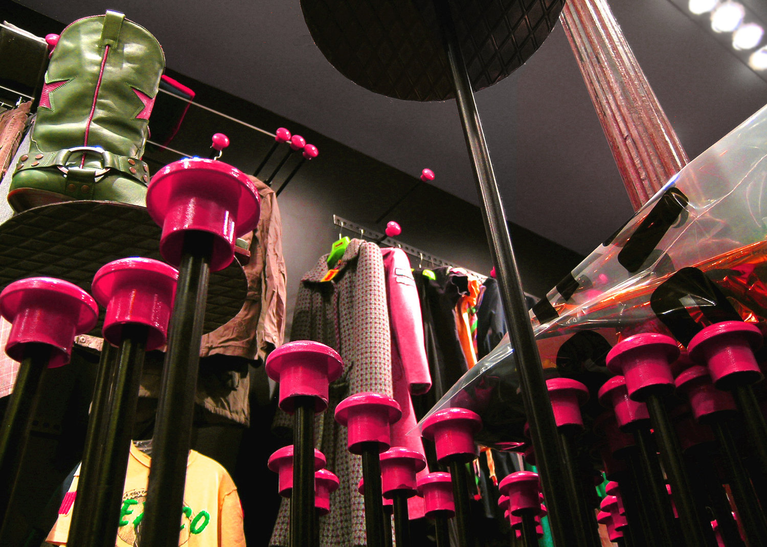 The pins are big hangers which are stuck in the wall, within a deliberate disorder which lets the different clothes be hanged up facing forward or in a side view, hanging or folded, capable of locating the various types of clothing from the front or in profile, hung or folded, higher or lower depending on their importance or quantity. They are benches and tables, and bracket of the counter and a showcase. The heads of the pins are protective mushrooms used in framework (reinforced concrete), which also assume the ephemeral nature of this intervention, changing in color, size, shape, every year with low cost.