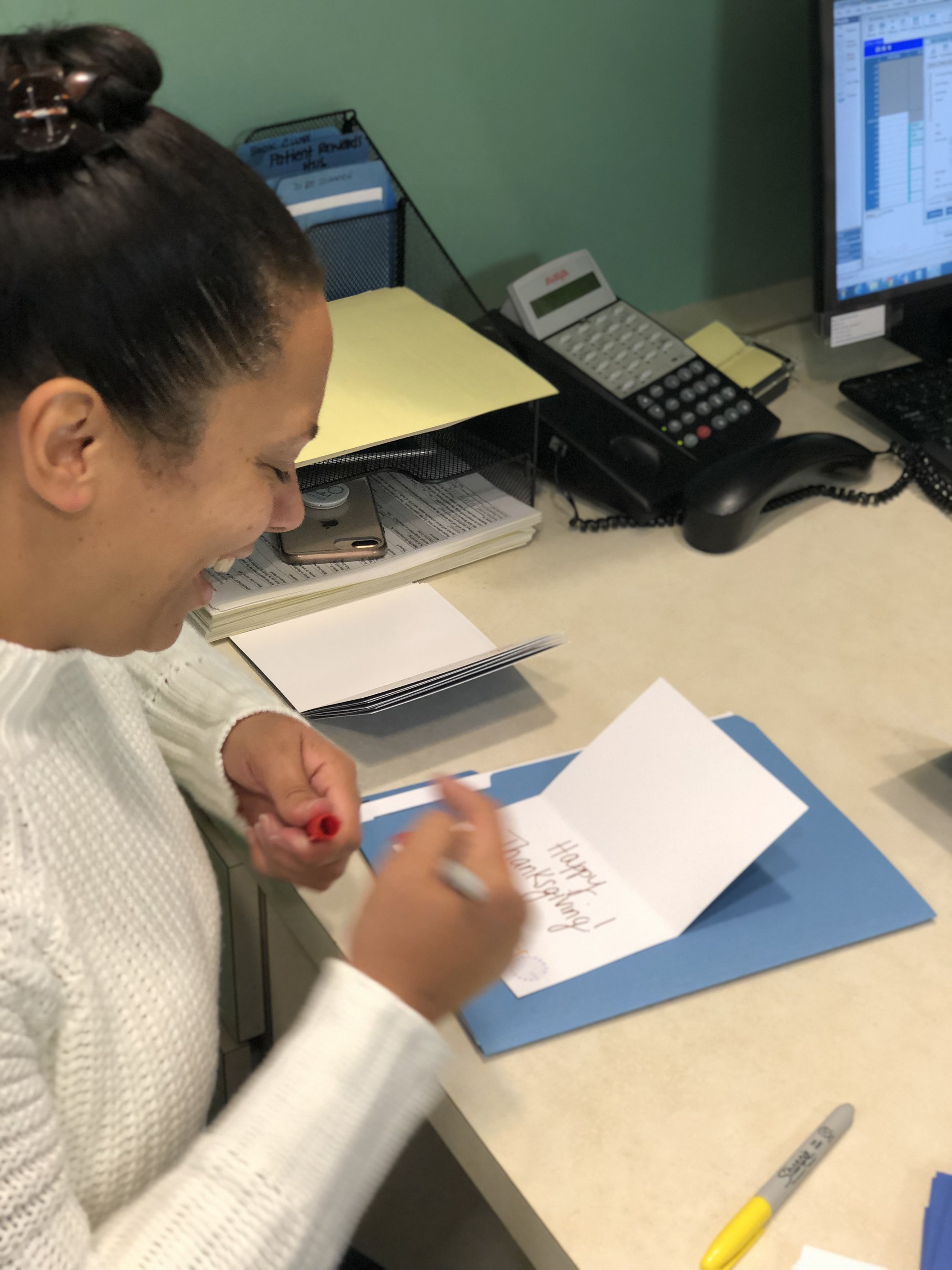 Gerlein team member signing a card to be given with donated thanksgiving food items. 